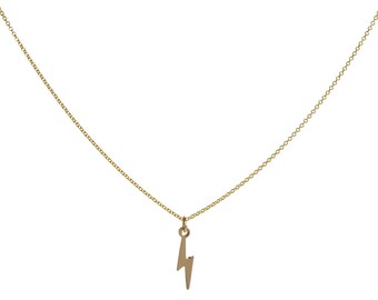 May include: A gold chain necklace with a lightning bolt pendant.