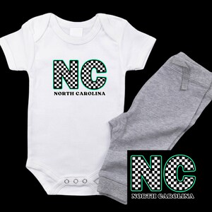 May include: White baby onesie with a black and white chequered 'NC' for North Carolina. Matching grey sweatpants with the same design.