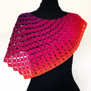 Könnte beinhalten: Ein handgehäkelter Schal in einem Farbverlauf, der von tiefem Lila über leuchtendes Pink bis hin zu Orange reicht. Das offene Design erzeugt einen strukturierten, luftigen Look. Der Schal ist über einer schwarzen Form drapiert.