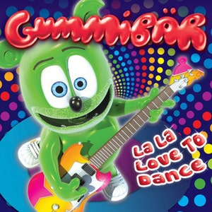 May include: A green gummy bear with a big smile is playing a pink and yellow electric guitar. The bear is wearing a white shoe and the background is a blue and purple polka dot pattern. The text "La La Love To Dance" is written in white letters on the bottom right corner of the image.