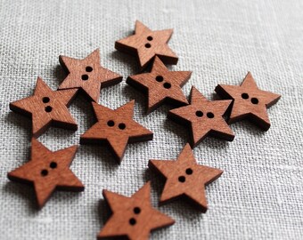 May include: A collection of ten brown wooden star-shaped buttons. The buttons have two holes each.