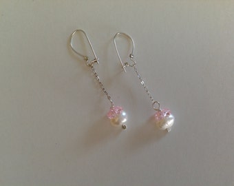 May include: A pair of silver dangle earrings with pink beads and white pearl accents.