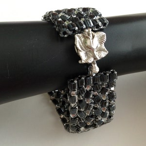 Shiny black beaded bracelet with flower clasp
