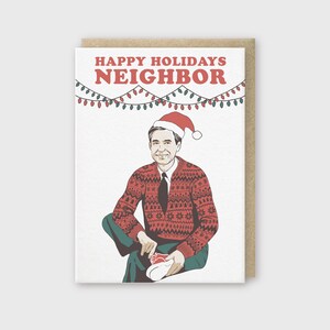 May include: A Christmas card featuring a cartoon illustration of Mr. Rogers wearing a Santa hat and a red and white patterned sweater. The card reads "Happy Holidays Neighbor".