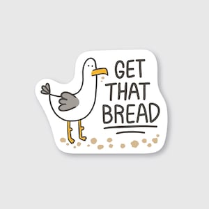 May include: A white cartoon seagull with yellow beak and gray wings stands on a beach with the text "GET THAT BREAD" in black.