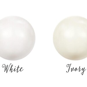 May include: Two round, smooth, pearl-like beads, one white and one ivory.
