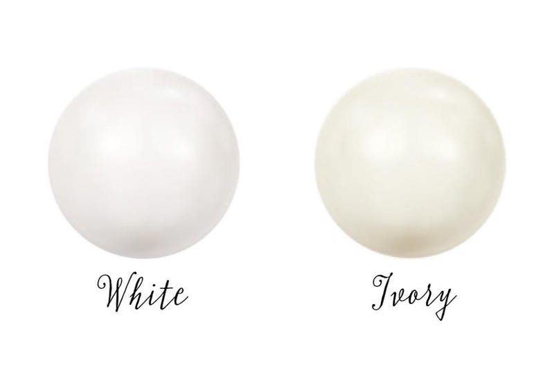 May include: Two round, smooth, pearl-like beads, one white and one ivory.