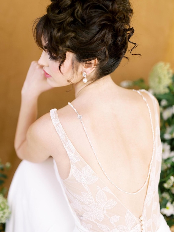 necklace for low cut wedding dress Back Necklaces: The Perfect Accessory for Open-Back Wedding Dresses An open- back gown is already breathtaking but add a back necklace, and your entire bridal look transforms into pure elegance. This delicate