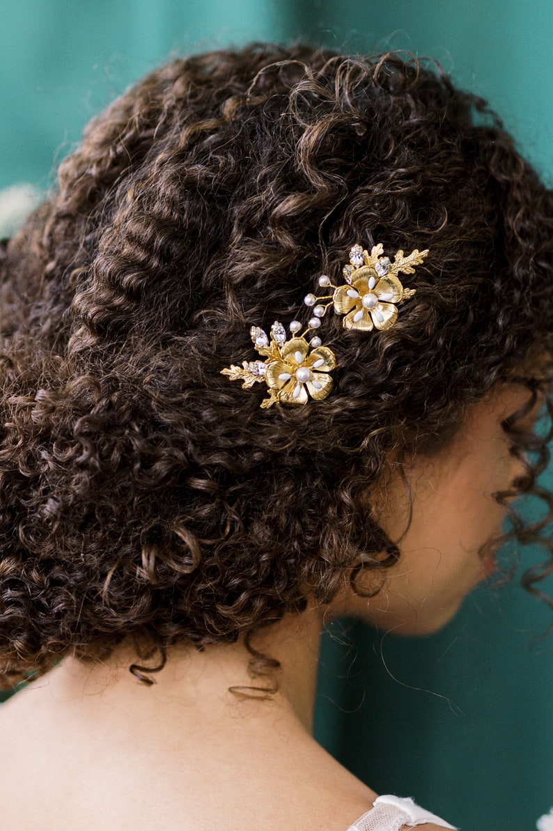 A beautiful pair of simple bridal hair pins with an oversized floral bloom, enamel painted centres and pearls.  Each flower is accented with sprigs of round glass pearls, sparkling crystals and oak leaves. Handmade in Toronto Canada by Blair Nadeau