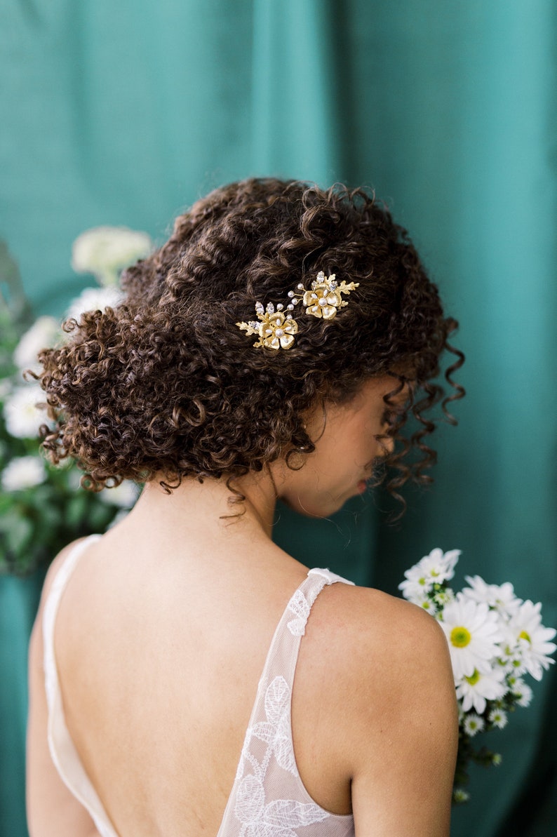 A beautiful pair of simple bridal hair pins with an oversized floral bloom, enamel painted centres and pearls.  Each flower is accented with sprigs of round glass pearls, sparkling crystals and oak leaves. Handmade in Toronto Canada by Blair Nadeau