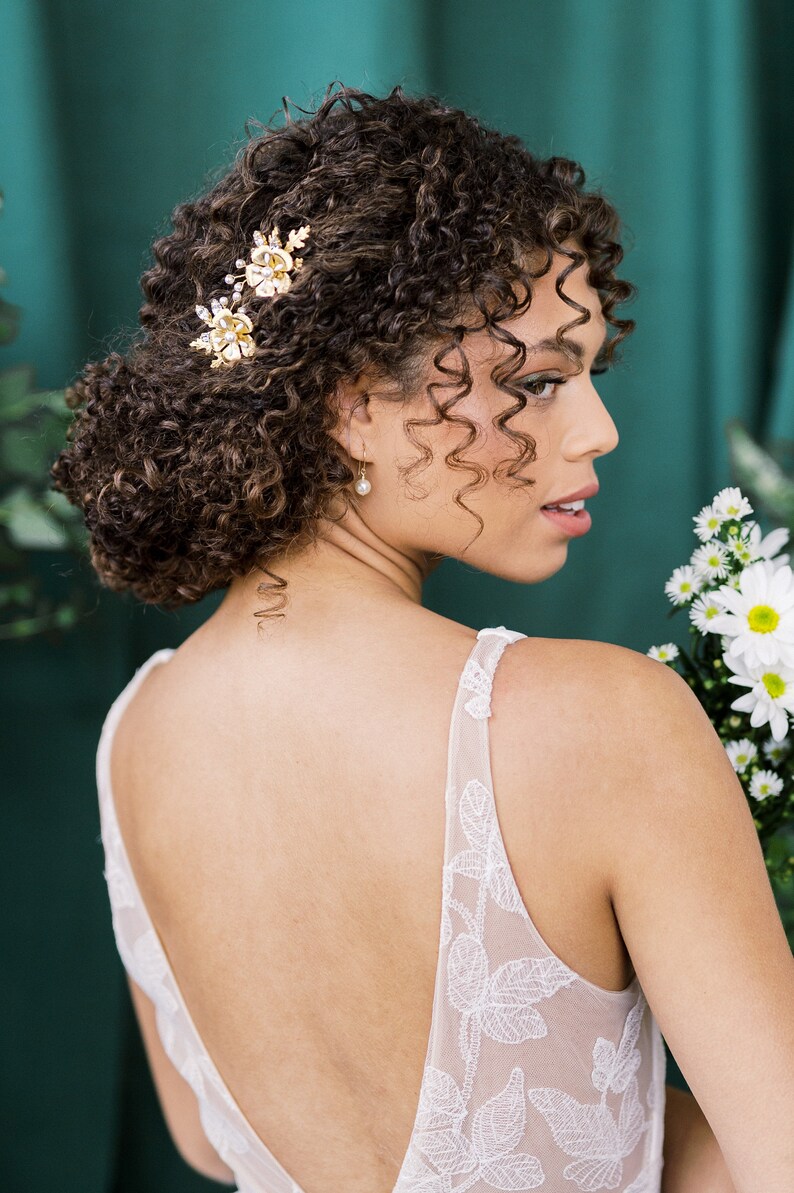 A beautiful pair of simple bridal hair pins with an oversized floral bloom, enamel painted centres and pearls.  Each flower is accented with sprigs of round glass pearls, sparkling crystals and oak leaves. Handmade in Toronto Canada by Blair Nadeau