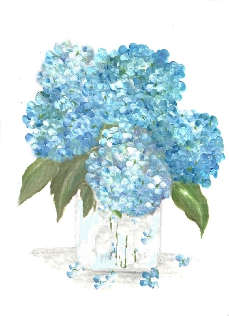 May include: A bouquet of blue hydrangeas in a clear glass vase with a white background. The hydrangeas are arranged in a loose, natural style, and the vase is simple and elegant.