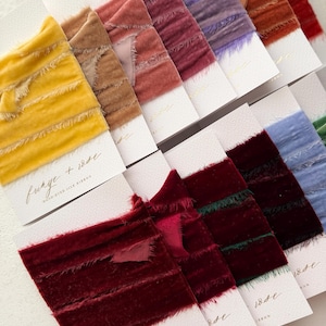 Può includere: Una collezione di nastri di seta tinti a mano in vari colori, tra cui giallo, marrone, rosa, viola, arancione, rosso e blu. Ogni nastro è attaccato a una scheda bianca con il testo "funge + iode HAND-DYED SILK RIBBON". I nastri hanno una trama sfrangiata.
