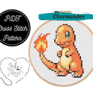 May include: A cross stitch pattern for a Charmander Pokemon. The pattern is in a hoop and shows a pixelated image of Charmander with a flame tail.