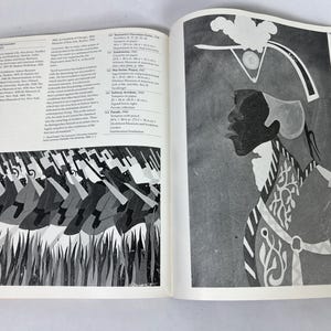 May include: An open art book displaying two pages of black and white illustrations. The left page shows a repeating pattern of figures in motion, while the right page features a profile portrait of a person wearing a decorative military-style hat.