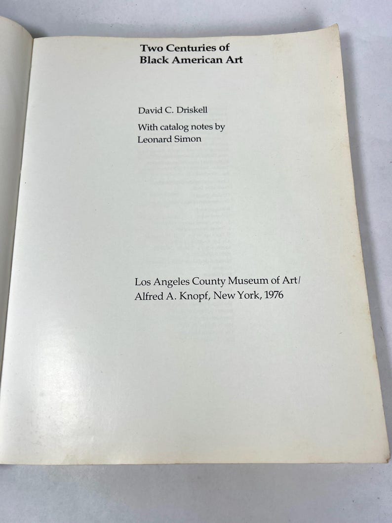May include: A white title page from the book Two Centuries of Black American Art by David C. Driskell, with catalog notes by Leonard Simon, published by the Los Angeles County Museum of Art and Alfred A. Knopf in New York in the year 1976.