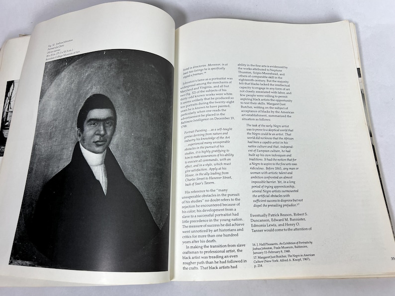 May include: An open book page featuring a black and white portrait of a man in a dark coat with a high collar, set against a circular background. The adjacent page contains printed text columns discussing the artist Joshua Johnson and his work.