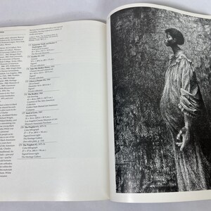 May include: An open art book featuring a biography of Charles White on the left page and a full-page black and white illustration of a person in a long, textured robe on the right page. The text includes detailed lists of artworks and exhibitions.