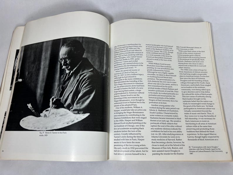 May include: An open book featuring a black and white photograph of an artist holding a paintbrush and palette on the left page, with printed text columns on the right page. The caption below the image reads, Fig. 37: Henry O. Tanner in his Paris studio, 1939.