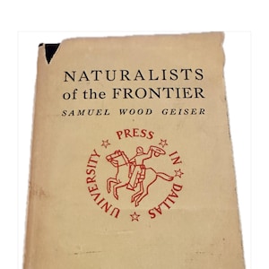 May include: A vintage book titled "NATURALISTS of the FRONTIER" by Samuel Wood Geiser. The cover is a faded tan color with black text and a red seal from the University in Dallas. The book has a worn appearance.