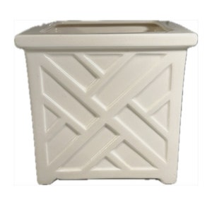 May include: White ceramic planter with a square shape and a geometric lattice design. The planter has a smooth, glossy finish.