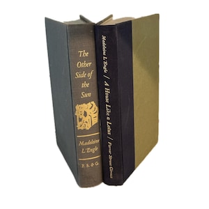 Puede incluir: Dos libros de tapa dura de pie. El libro de la izquierda se titula "The Other Side of the Sun" de Madeleine L'Engle. El libro de la derecha se titula "A House Like a Lotus" de Madeleine L'Engle.