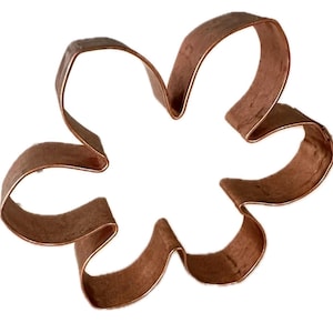 May include: A copper-colored, flower-shaped cookie cutter. The cutter has six curved petals and is made of a thin, folded metal. The design is simple and elegant, perfect for baking floral-themed cookies or pastries.