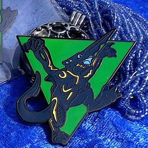 Puede incluir: Dos pines de esmalte negro y verde con forma de triángulos. Cada pin presenta una criatura negra con detalles amarillos. Los pines están sobre un fondo azul. El texto "Kawaii Ju" y "Knifehead" está en los pines.