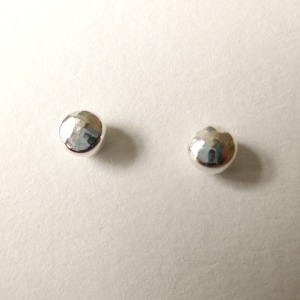 May include: A pair of silver stud earrings with a hammered finish.