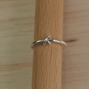 A sterling silver fidget ring on a wooden surface.