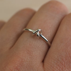 A sterling silver fidget ring with a knotted bead and simple design.
