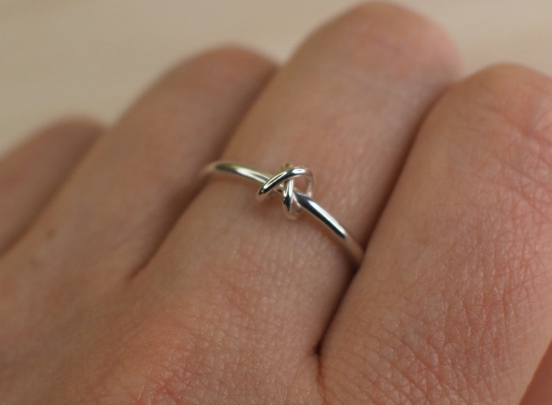 A sterling silver fidget ring with a knotted bead and simple design.