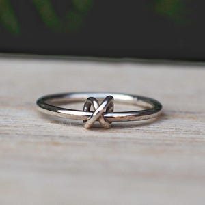 A sterling silver fidget ring with a spinning knotted bead and simple design.