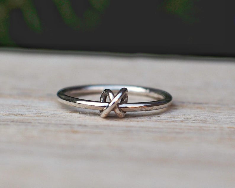 A sterling silver fidget ring with a spinning knotted bead and simple design.