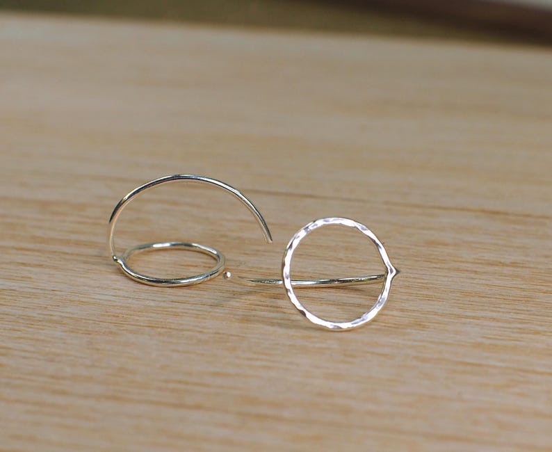 Two silver circle hoop earrings, with a shiny hammered finish.