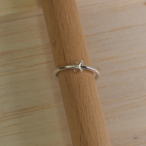 A silver fidget ring with a free moving bead in a knot design.