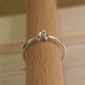 A simple sterling silver beaded fidget ring on a wooden surface.