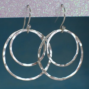 May include: Silver double hoop earrings with a hammered texture.