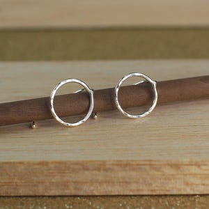 Two sterling silver hammered circle earrings with a polished finish.