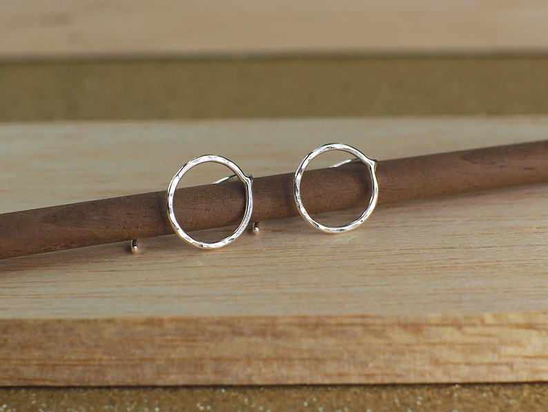 Two sterling silver hammered circle earrings with a polished finish.