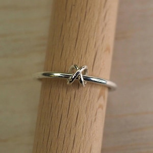 A sterling silver fidget ring with bead on a wooden surface.