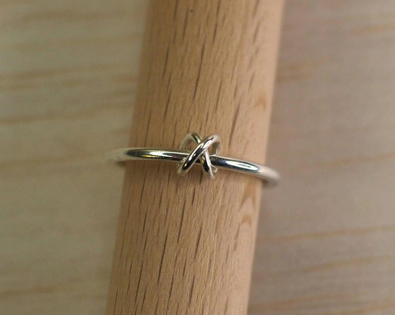 A sterling silver fidget ring with bead on a wooden surface.