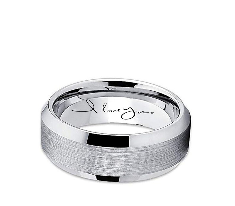 May include: A silver-colored ring with a brushed center band and polished edges. The inner band features the handwritten phrase "I love you." The ring has a modern, minimalist design.