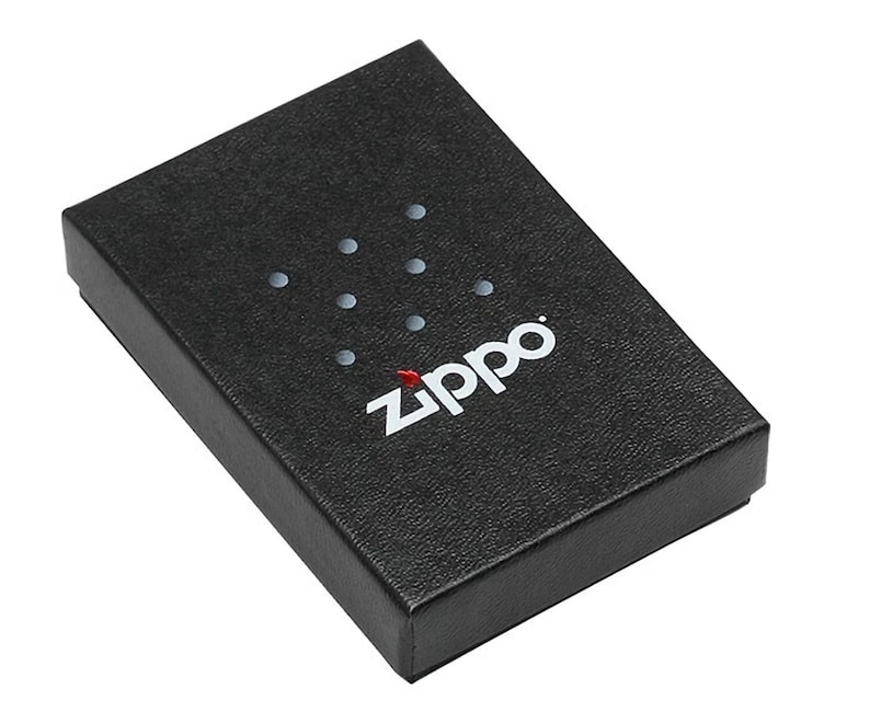 Puede incluir: Una caja negra texturizada con el logotipo de Zippo en blanco y una llama roja. La caja tiene forma rectangular y una tapa. Hay siete peque&ntilde;os puntos plateados espaciados uniformemente encima del logotipo.