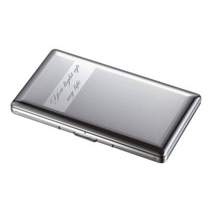 May include: Silver cigarette case with a textured surface and the inscription "You light up my life".