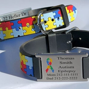 May include: Two black silicone bracelets with puzzle piece designs in red, yellow, blue, and green. One bracelet has the address "22 Heller Dr" engraved. The other has a medical alert tag with a ribbon symbol and the words "Autism" and "Epilepsy".
