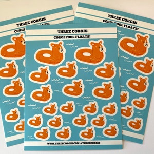May include: A sheet of stickers featuring illustrations of corgis wearing orange pool floats. The stickers are on a blue background with white waves. The text "Three Corgis Corgi Pool Floats!" is at the top of the sheet. The website address "www.threecorgis.com @threecorgis" is at the bottom of the sheet.