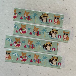 May include: Four rolls of washi tape featuring a repeating pattern of corgis in various summer-themed outfits. The corgis are wearing sunglasses, hats, and life jackets. The background is a light green with palm trees, beach umbrellas, and watermelon slices.