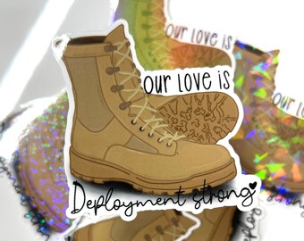 Puede incluir: Una pegatina con un par de botas militares marrones y el texto "Our love is Deployment strong" con un pequeño corazón.