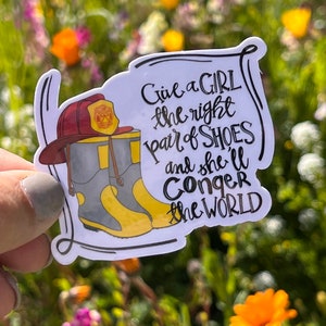 May include: A white sticker with black text that reads "Give a girl the right pair of shoes and she'll conquer the world". The sticker features a cartoon illustration of a pair of yellow and grey boots with a red firefighter helmet on top.
